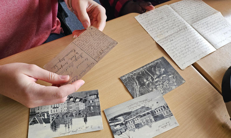 Schüler*innen lesen alte Postkarten und Briefe