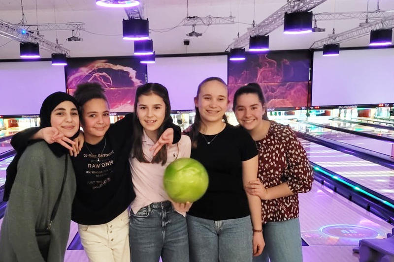 Eine Gruppe von Schülerinnen auf einer Bowlingbahn