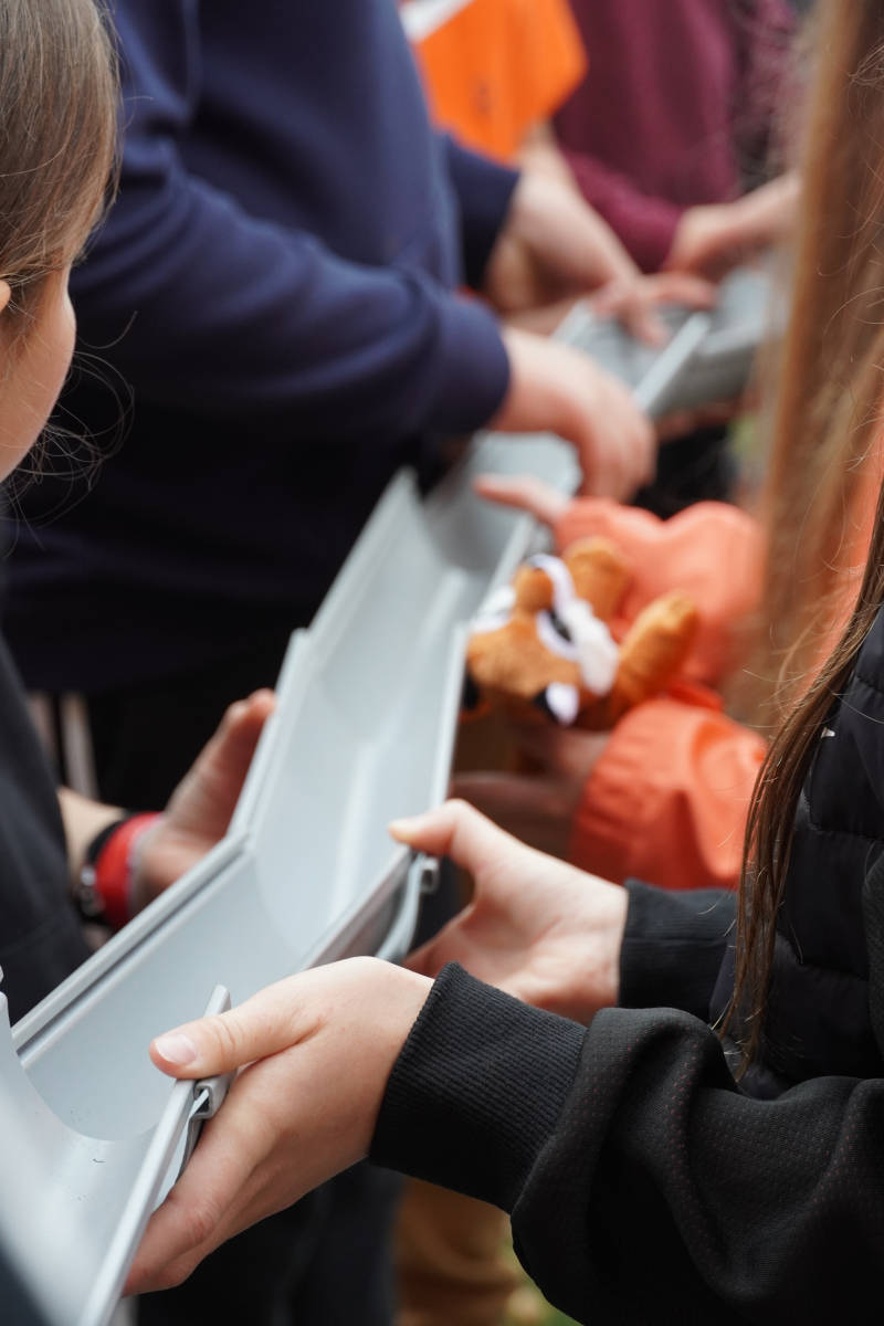eine Gruppe von Schüler*innen hält Elemente einer Regenrinne