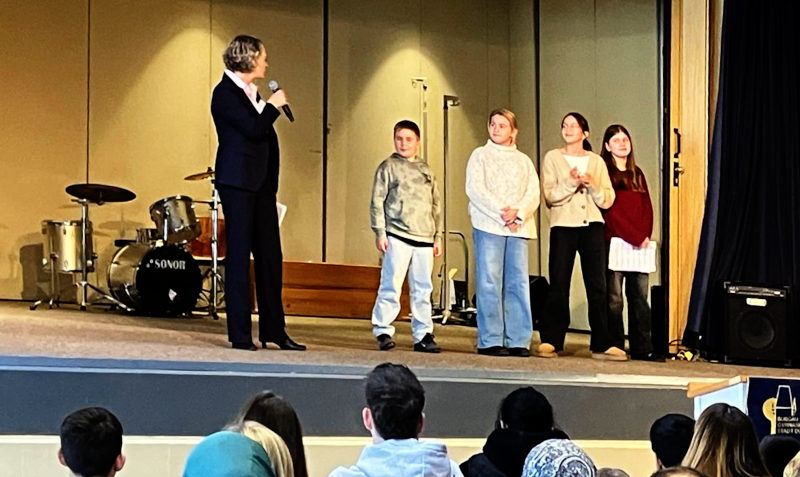 Schüler*innen und die kommissarische stellvertretende Schulleiterin auf der Bühne des Burgau-Gymnasiums