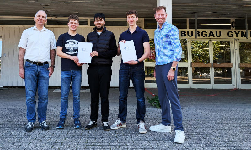 Schüler, Herr Dr. Heidbüchel, Herr Fender vor dem Eingang des Burgau-Gymnasiums