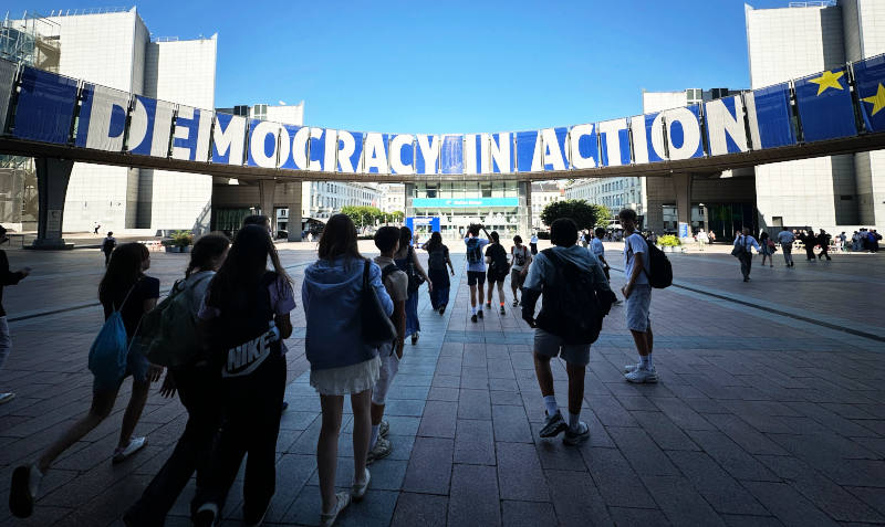 Schüler*innen vor Schriftzug »Democracy in Action«